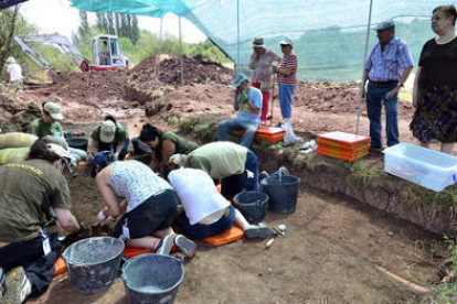 Descendientes y vecinos de Barcones observan los trabajos en la fosa mientras la excavadora busca el segundo enterramiento. / ÁLVARO MARTÍNEZ-