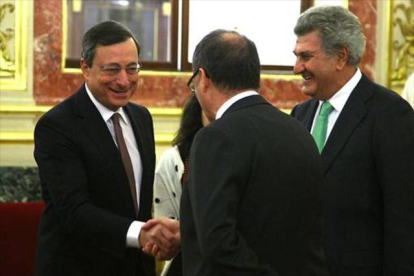 El presidente del BCE, Mario Draghi, saluda al gobernador del Banco de España, Luis María Linde.-AGUSTÍN CATALÁN