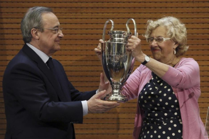 Florentino Pérez le entrega a Manuel Carmena, alcaldesa de Madrid, una réplica de la Champions.-FERNANDO ALVARADO