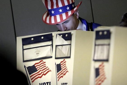 Un hombre vestido como el Tio Sam  ejerce su derecho al voto en un centro electoral en el eastside de Nueva York en las eleccines presidenciales del 2016.-EFE / PETER FOLEY