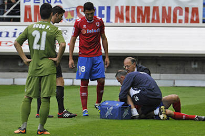 Antonio Tomás es atendido por los servicios médicos del Numancia tras su lesión ante el Sporting. / DIEGO MAYOR-