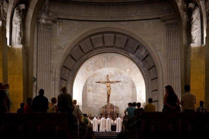 Los monjes benedictinos concelebran una de sus misas diarias en el altar junto al que se encuentra la tumba de Francisco Franco.-JOSÉ LUIS ROCA