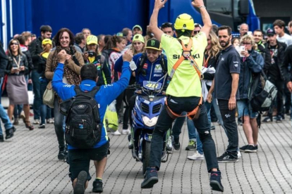 Valentino Rossi abandonó ayer el 'paddock' de Assen entre vítores de profesionales de otros equipos, como los de Suzuki que aparecen en esta imagen.-ALEJANDRO CERESUELA