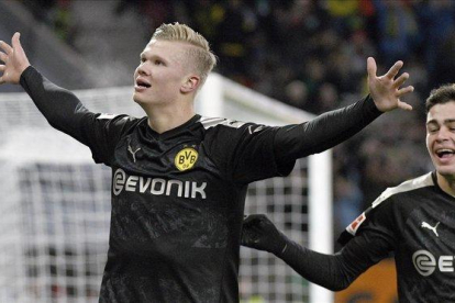 Erling Haaland celebra su tercer gol al Augsburgo en su debut liguero con el Dortmund.-AP