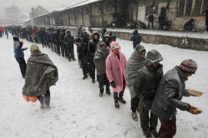 Inmigrantes reciben comida en el exterior de un almacén aduanero abandonado en Belgrado, Serbia.-REUTERS / MARKO DJURICA