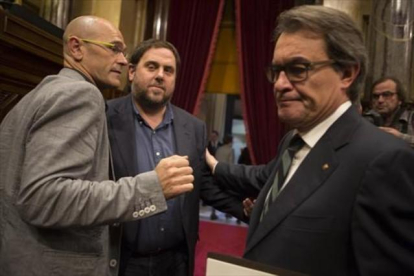 Raül Romeva, Oriol Junqueras y Artur Mas se saludan al terminar la sesión matinal del Parlament de ayer.-ALBERT BERTRAN