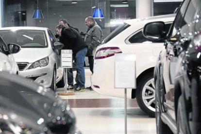 Clientes de un concesionario muestran interés por un modelo a la venta.-Foto: JULIO CARBÓ