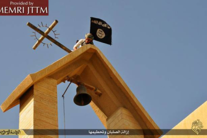Terroristas del Estado Islámico colocan su bandera en una iglesia cristiana en el norte de Irak.-