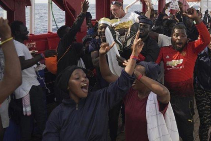 Los inmigrantes del ’Ocean Viking’ celebran que van a poder desembarcar este martes en Italia.-AP / RENATA BRITO