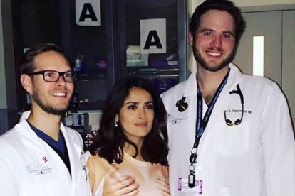 Salma Hayek, con la camiseta que representa unas manos cogiéndole los pechos, posa con los doctores que la han atendido de urgencia en el hospital.-INSTAGRAM