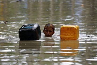 Uno de los miles de afectados por las lluvias torrenciales que han afectado a Birmania espera la llegada de los efectivos de rescate.-Foto: EFE / LYNN BO BO