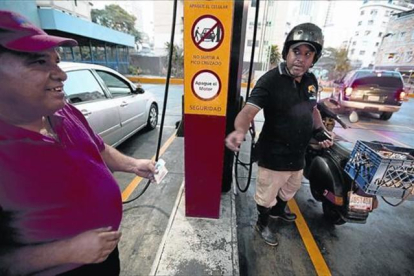 Un motorista paga, ayer, el combustible en una gasolinera de Caracas.-AFP / FERNANDO LLANO