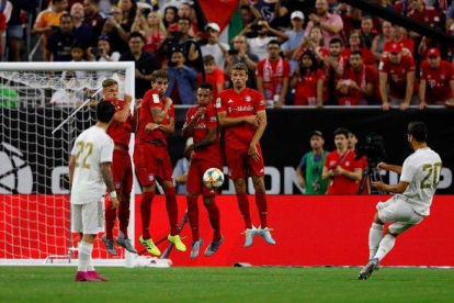 El madridista Isco (d) lanza una falta durante el Bayern-Real Madrid.-AFP