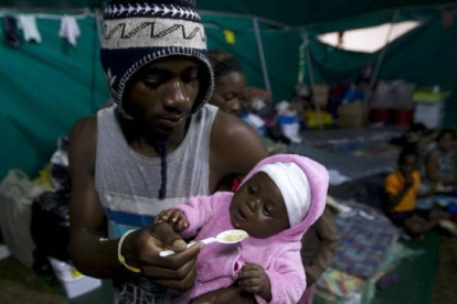 Un extranjero alimenta a su bebé en una tienda donde han sido realojados en Isibingo, en el sur de Durban, este lunes.-Foto:   REUTERS / ROGAN WARD
