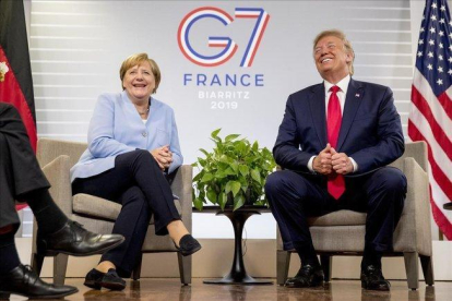 El presidente norteamericano Donald Trump y la cancillera alemana Angel Merkel se ríen durante la cumbre del G/ en Biarritz.-ANDREW HAMIK (AP)