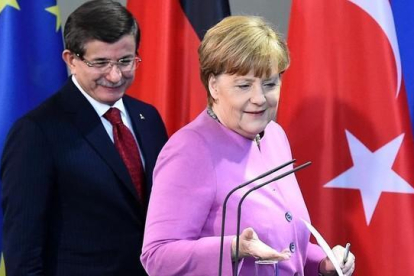 Davutoglu y Merkel se disponen a celebrar una conferencia de prensa, tras su encuentro en la cancillería, en Berlín, este viernes.-AFP / TOBIAS SCHWARZ
