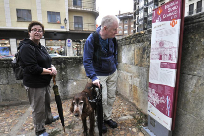Una pareja de turistas y su perro se detienen a informarse sobre la iglesia de Santo Domingo.-VALENTÍN GUISANDE