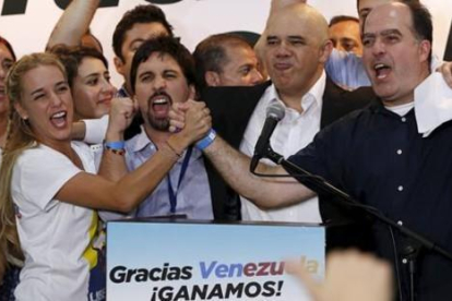 Lilian Tintori (izq), esposa del dirigente encarcelado Leopoldo López, celebra con otros representantes de la MUD la victoria electoral, en Caracas.-REUTERS / CARLOS GARCÍA RAWLINS