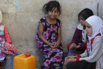 Niñas yemenís esperan para coger agua en una fuente potable en Saná.-EFE