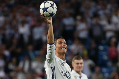 Cristiano Ronaldo luce el balón que se llevó como recompensa a los tres goles anotados ante el Bayern.-SERGIO PÉREZ