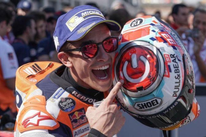 Marc Márquez señala, feliz, el interruptor que tiene dibujado sobre su casco.-ALEJANDRO CERESUELA
