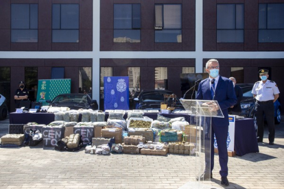 Cientos de kilos de droga ante coches de alta gama en la presentación de la operación policial. ICAL