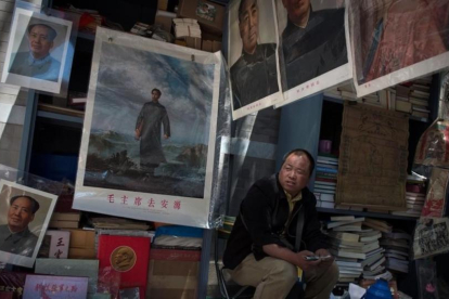 Un comerciante espera la llegada de clientes para vender imágenes y recuerdos de Mao Zedong.-AFP / NICOLAS ASFOURI