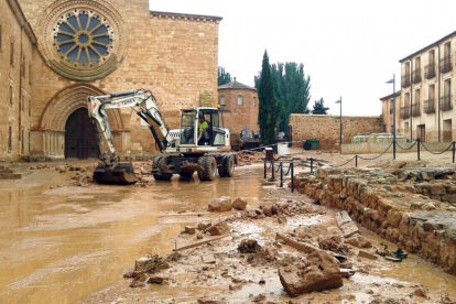 Una excavadora trabaja para retirar los cascotes acumulados junto al monasterio.-CEDIDA