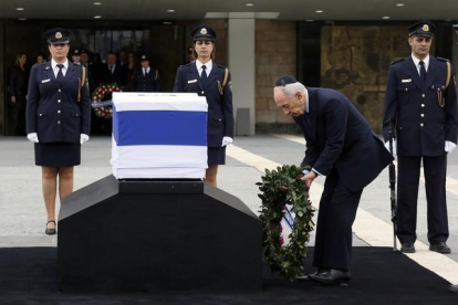 El presidente israelí Shimon Peres rinde tributo al exprimer ministro fallecido el sábado.-GALI TIBBON / AFP
