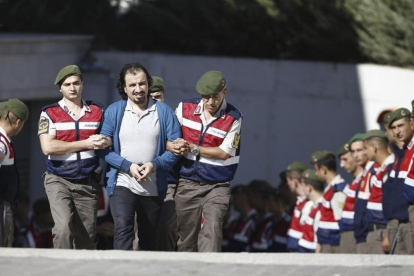 Soldados turcos escoltan a los 47 acusados de planificar el asesinato de Erdogan, antes de su juicio en Mungla (Turquía), el 4 de octubre-EFE / MUSTAFA CIFTCI