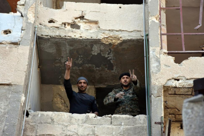 Soldados sirios en Alepo hacen la señal de la victoria.-EFE