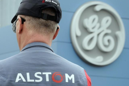 Un empleado de Alstom frente a un logo de GE, durante las negociaciones de la compra.-SEBASTIEN BOZON (AFP)