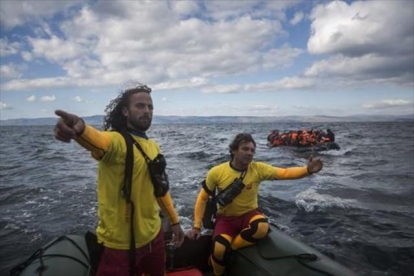 Dos miembros de Proactiva Open Arms socorren a refugiados en el Egeo.-AP / SANTI PALACIOS