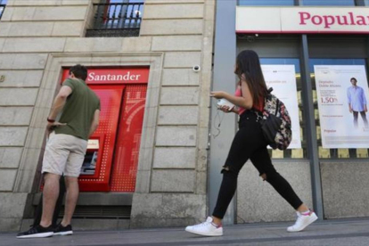 Una oficina del Santander, junto a otra del Popular, en Madrid.-JUAN MANUEL PRATS