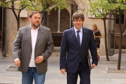 El 'president' Puigdemont y el vicepresidente Junqueras llegando a la reunión del Govern este martes.-RICARD CUGAT