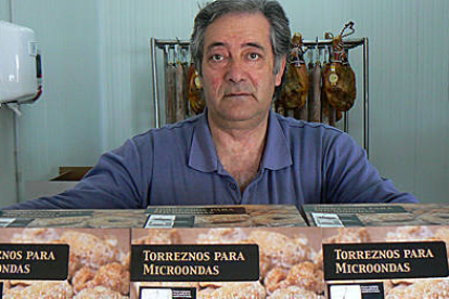 Florencio Jiménez posa delante de los envases de torreznos para microondas. / EVA SÁNCHEZ-