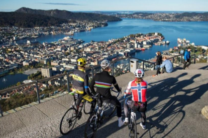 Tres ciclistas contemplan una panorámica de Bergen.-PERIODICO (BERGEN 2017)