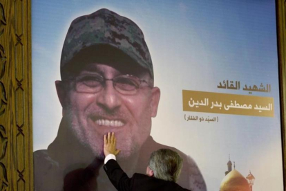 Adnan Badriddine toca la foto del su hermano, Mustafa, en el homenaje al jefe militar de Hizbolá en El Líbano.-AP / HASSAN AMMAR