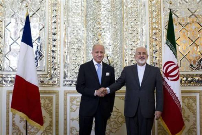 Los ministros de Exterior iraní y francés, Mohammad Javad Zarif (derecha) y Laurent Fabius (izquierda) se dan la mano antes de su reunión en Teherán este miércoles.-Foto: AFP/ ROUZ MEHRI