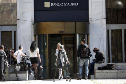 Varios periodistas esperan a las puertas de la sede del Banco de Madrid.-Foto: DAVID CASTRO