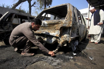 Un policía inspecciona el lugar del atentado cometido por un talibán contra un tribunal en Pakistán.-REUTERS / FAYAZ AZIZ