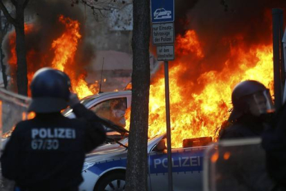 Coches de policía pasto de las llamas. KAI PFAFFENBACH | REUTERS