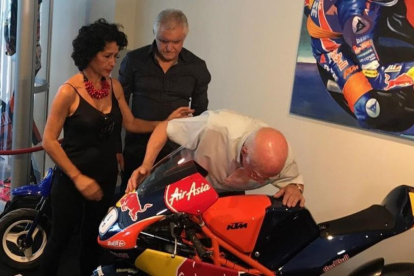 Toni Salom, abuelo del fallecido joven piloto mallorquín, besa, entre lágrimas, la moto de su nieto Luis, en la inauguración hoy de una exposición en Palma.-EMILIO PÉREZ DE ROZAS