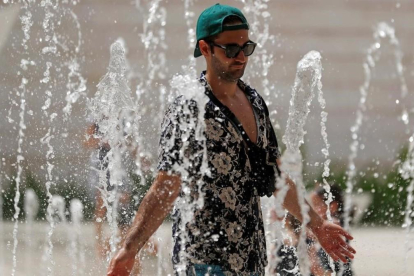 Un turista se refresca en una fuente de Lisboa.-REUTERS / RAFAEL MARCHANTE