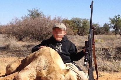 Un niño de siete años sostiene con la mano izquierda un rifle de casa y con la derecha acaricia el lomo del león que acaba de matar.-Foto:   © TWITTER / ALLEN TARPLEY