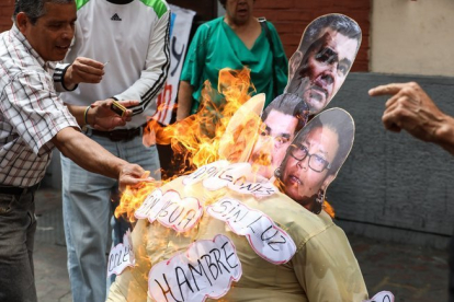 La quema de un muñeco con la foto de Nicolas Maduro y otros políticos de su gobierno.-EFE
