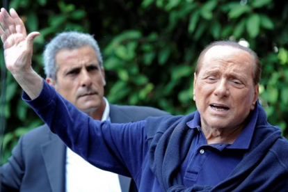 Silvio Berlusconi saluda a sus seguidores al salir del hospital.-STRINGER
