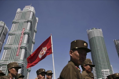 Un grupo de soldados norcoreanos caminan por la avenida Ryomyong donde se ha inaugurado un complejo de altos y modernos edificios.-AP