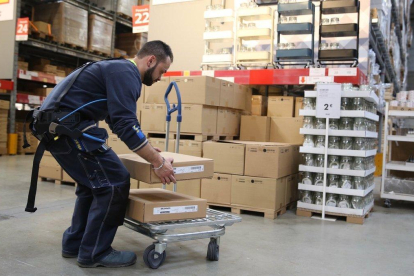 Borja, un empleado de Ikea en Badalona, lleva puesto un exoesqueleto para trabajar con facilidad y corregir errores.-JOSEP GARCÍA (EL PERIÓDICO)