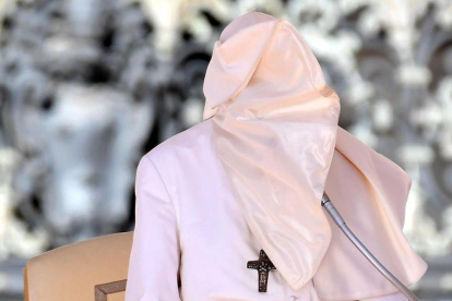 El Papa, con la cara tapada con el hábito a causa del fuerte viento que soplaba durante su intervención semanal ante los fieles en la plaza de San Pedro, en el Vaticano.-TIZINA FABI (AP)